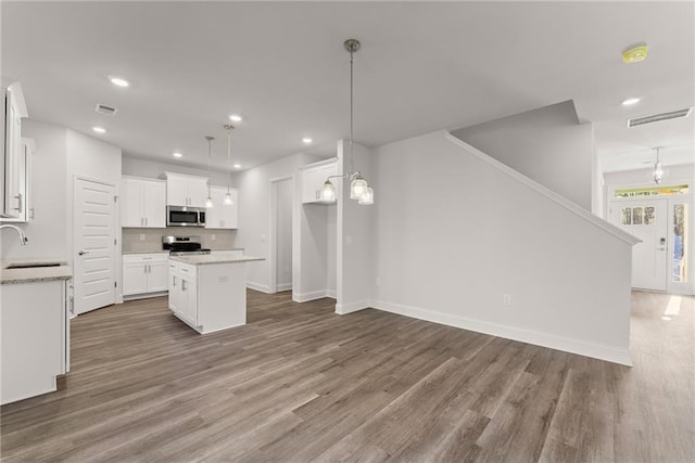kitchen with recessed lighting, a center island, visible vents, a sink, and stainless steel appliances