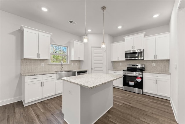 kitchen with stainless steel appliances, white cabinets, visible vents, and a sink