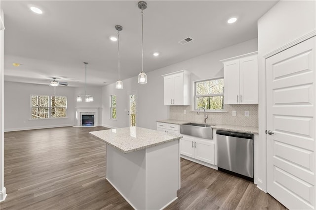 kitchen with a sink, visible vents, ceiling fan, backsplash, and dishwasher