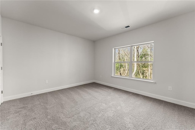 carpeted empty room with baseboards, visible vents, and recessed lighting