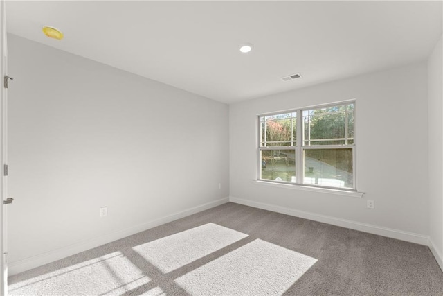 unfurnished room with carpet, visible vents, baseboards, and recessed lighting