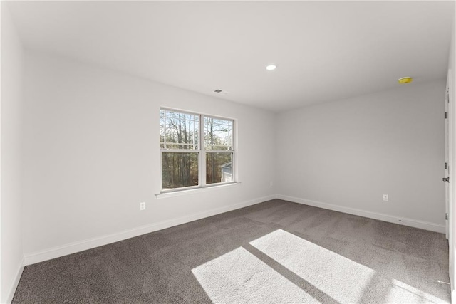 spare room featuring carpet flooring, baseboards, visible vents, and recessed lighting