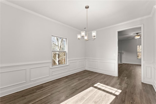 unfurnished dining area featuring dark wood-style flooring, a chandelier, wainscoting, and plenty of natural light