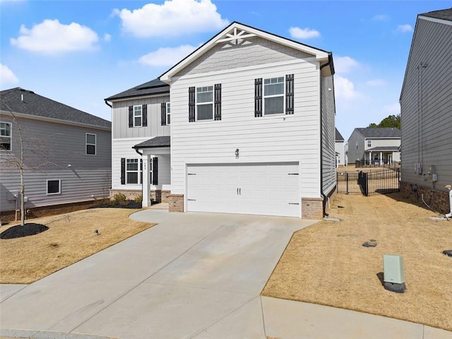 view of front of home with an attached garage, solar panels, fence, driveway, and board and batten siding