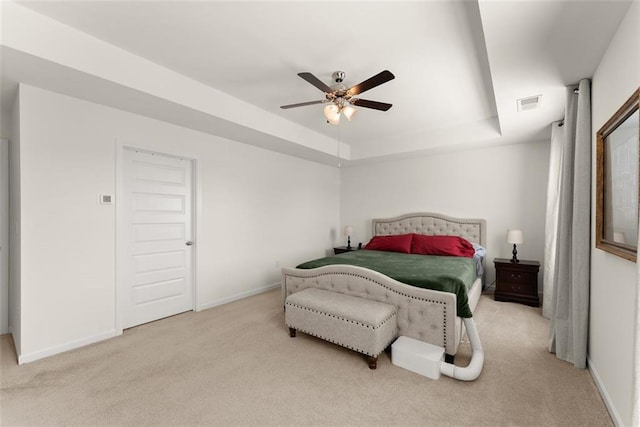 bedroom with baseboards, visible vents, a raised ceiling, ceiling fan, and carpet