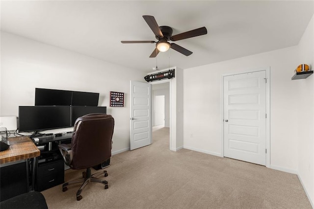 home office with baseboards, a ceiling fan, and light colored carpet