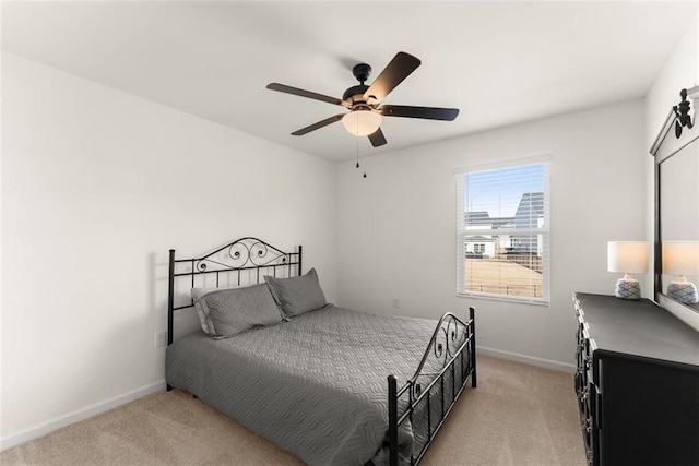 bedroom featuring baseboards, ceiling fan, and light colored carpet