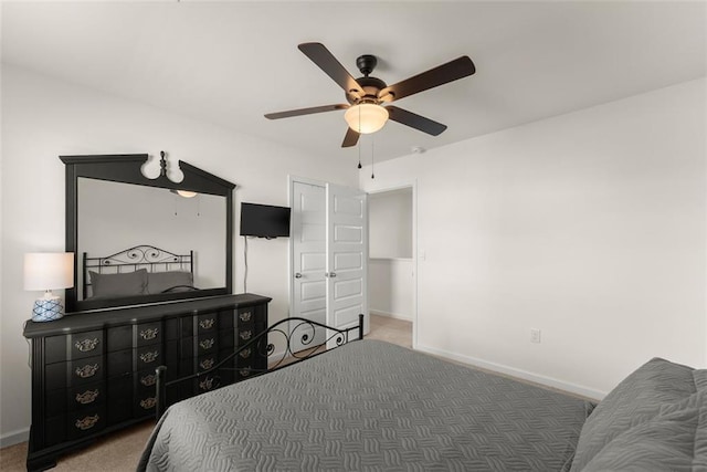 carpeted bedroom with a ceiling fan and baseboards