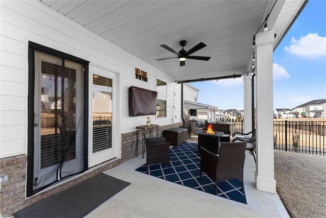 view of patio with ceiling fan, an outdoor fire pit, and fence