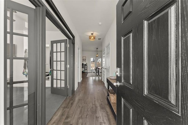 hallway featuring visible vents, wood finished floors, and french doors