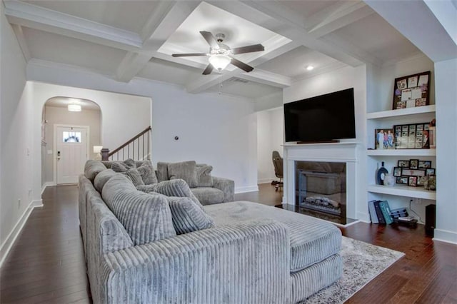 living room with dark hardwood / wood-style flooring, coffered ceiling, ceiling fan, beam ceiling, and built in features