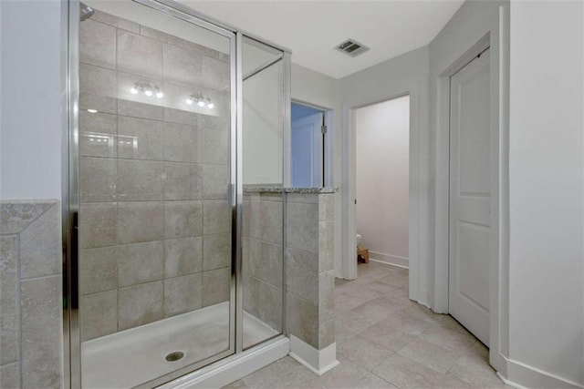 bathroom featuring tile patterned flooring, an enclosed shower, and toilet