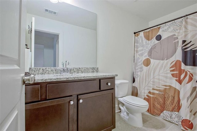 bathroom with a shower with shower curtain, vanity, toilet, and tile patterned floors