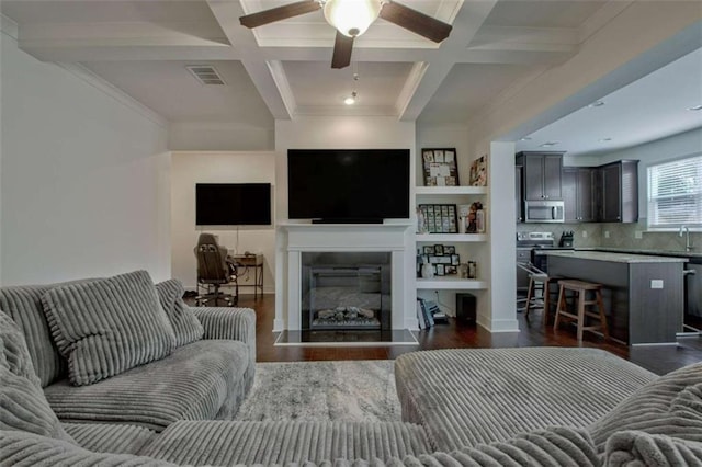 living room with beam ceiling, ceiling fan, sink, coffered ceiling, and dark hardwood / wood-style flooring