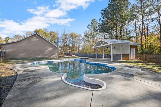 view of pool featuring ceiling fan, a diving board, and a patio area