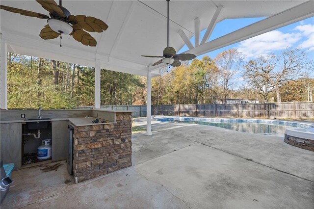 view of patio with a fenced in pool and an outdoor wet bar