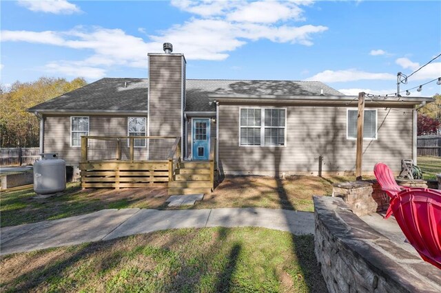 view of front facade featuring a front lawn and a wooden deck