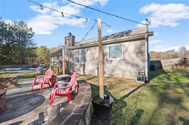 rear view of house with cooling unit, a patio area, and a yard