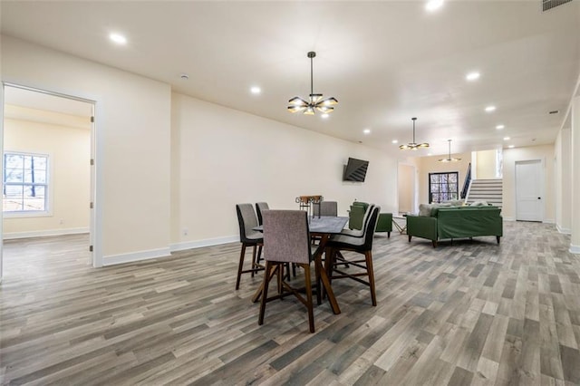 dining area featuring an inviting chandelier and hardwood / wood-style flooring