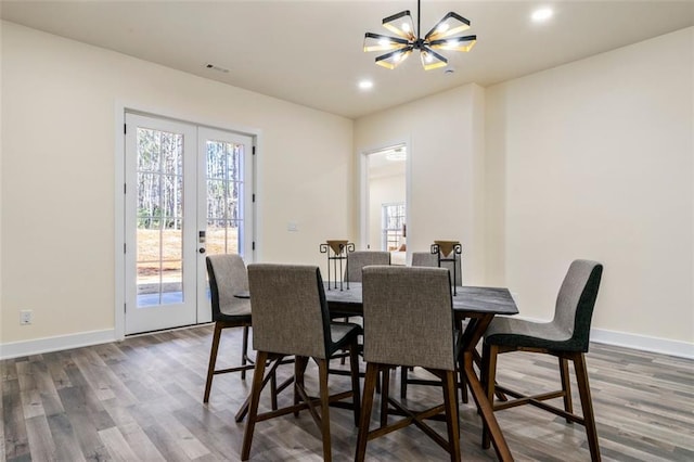 dining space with french doors, dark hardwood / wood-style floors, and a notable chandelier