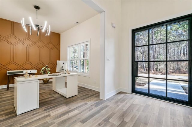 unfurnished office featuring a chandelier and hardwood / wood-style floors