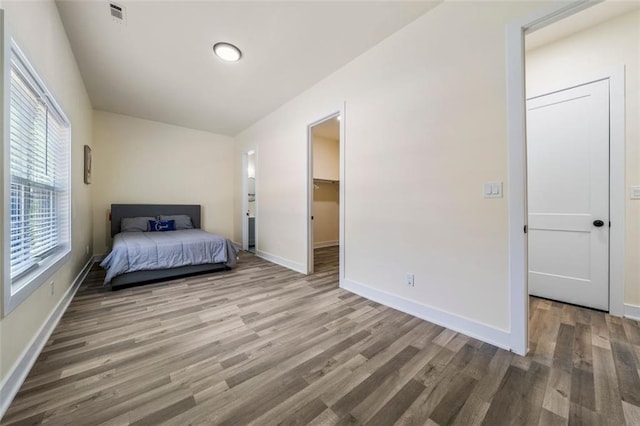 unfurnished bedroom featuring hardwood / wood-style floors and a spacious closet