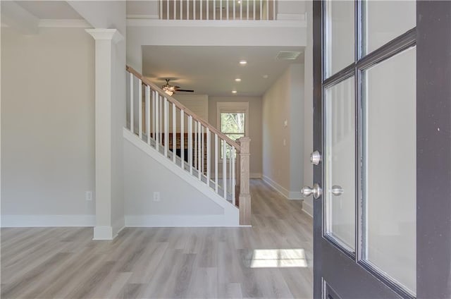 entryway featuring decorative columns, light hardwood / wood-style flooring, and ceiling fan