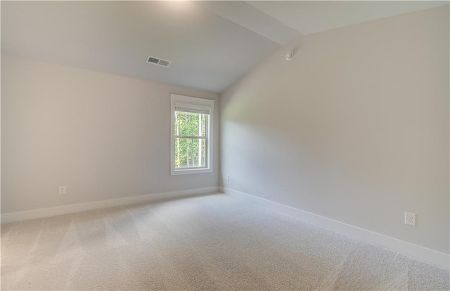 carpeted spare room featuring lofted ceiling