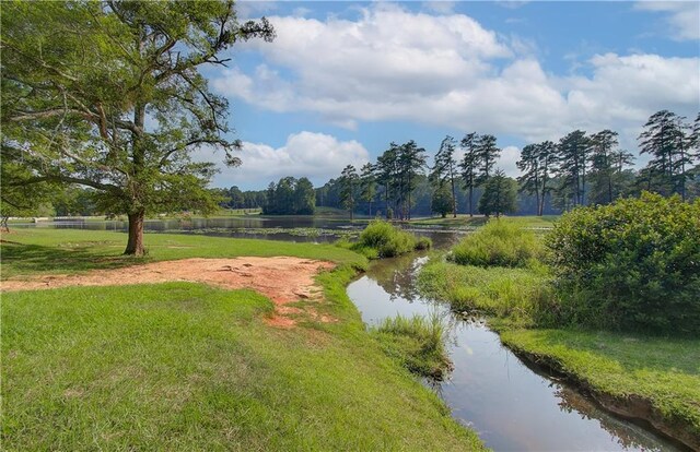 view of home's community featuring a water view and a yard