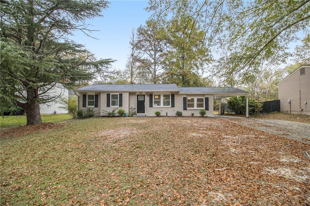 ranch-style home featuring a front yard and a carport