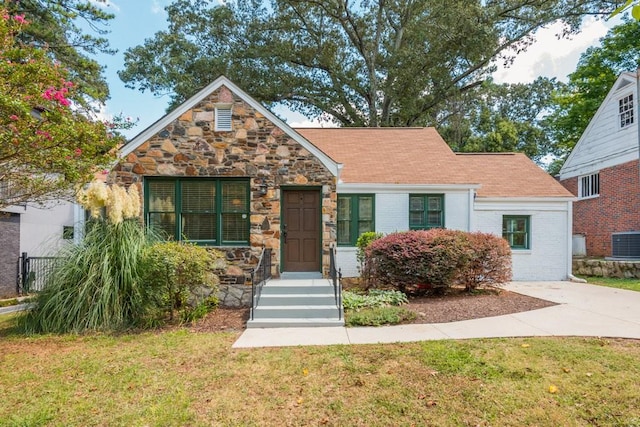 view of front of property featuring central AC unit and a front yard