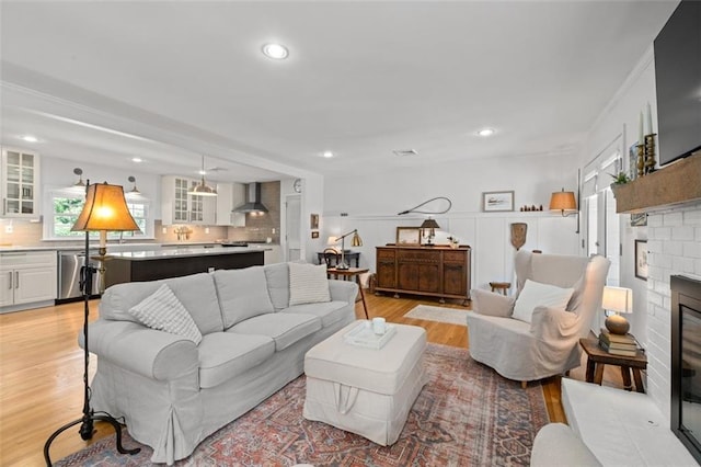 living room featuring light wood-type flooring, a fireplace, and recessed lighting