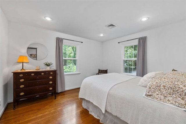 bedroom featuring multiple windows, wood finished floors, baseboards, and recessed lighting