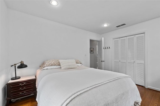 bedroom with wood finished floors, a closet, recessed lighting, and baseboards