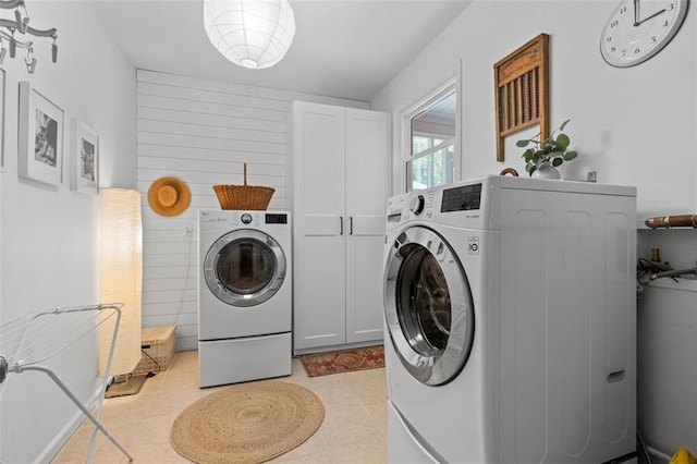 laundry area featuring cabinet space, washing machine and dryer, and light tile patterned floors