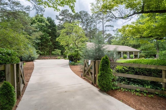 surrounding community featuring fence and concrete driveway
