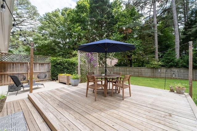 deck featuring outdoor dining area and view of scattered trees