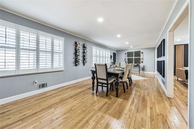 dining area featuring light hardwood / wood-style floors, a wealth of natural light, and ornamental molding