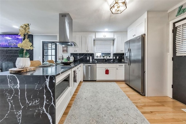 kitchen featuring stainless steel appliances, island range hood, and white cabinets