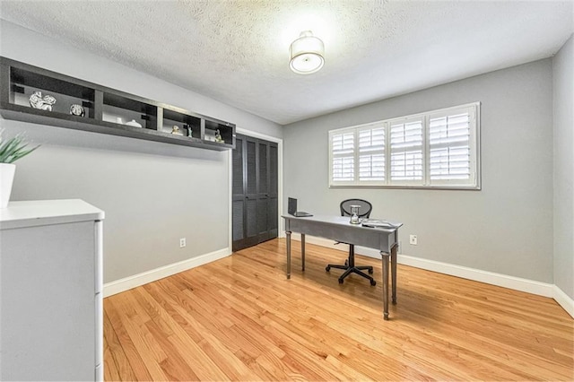 office space with light hardwood / wood-style floors and a textured ceiling