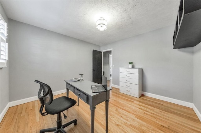 home office featuring a textured ceiling and light hardwood / wood-style floors