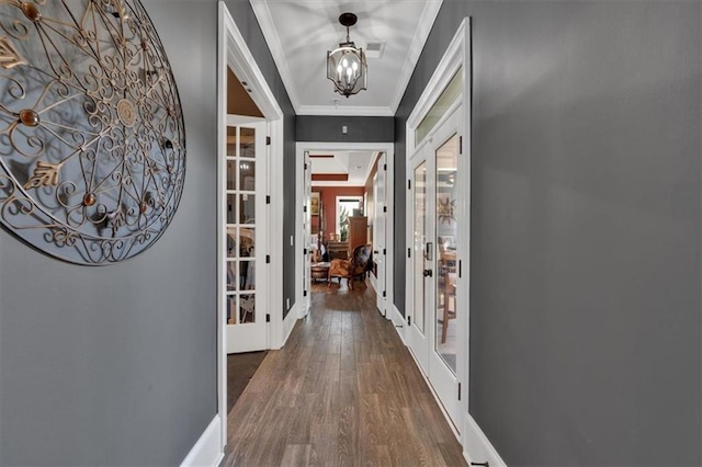 hall with an inviting chandelier, crown molding, french doors, and dark hardwood / wood-style floors