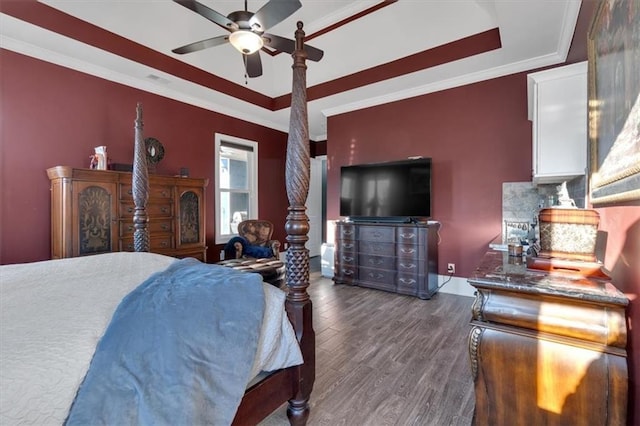 bedroom with a tray ceiling, dark hardwood / wood-style floors, and ornamental molding