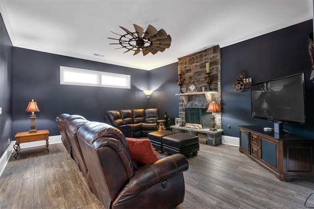 living room with a fireplace, hardwood / wood-style flooring, crown molding, and ceiling fan