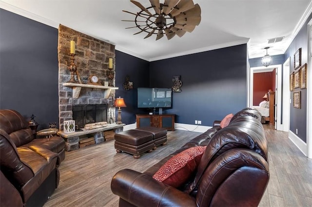 living room featuring a fireplace, ornamental molding, and hardwood / wood-style flooring