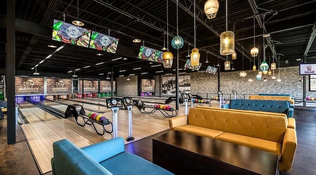 rec room featuring bowling, brick wall, and hardwood / wood-style flooring