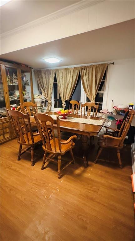 dining space featuring wood-type flooring and ornamental molding