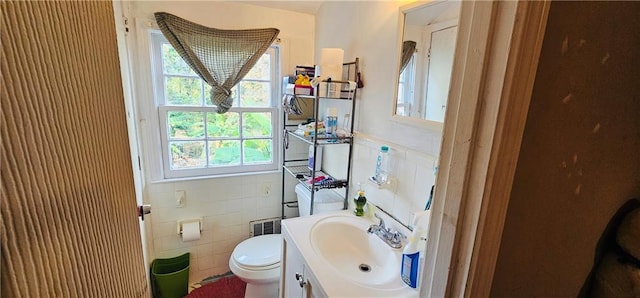 bathroom featuring a wealth of natural light, vanity, tile walls, and toilet