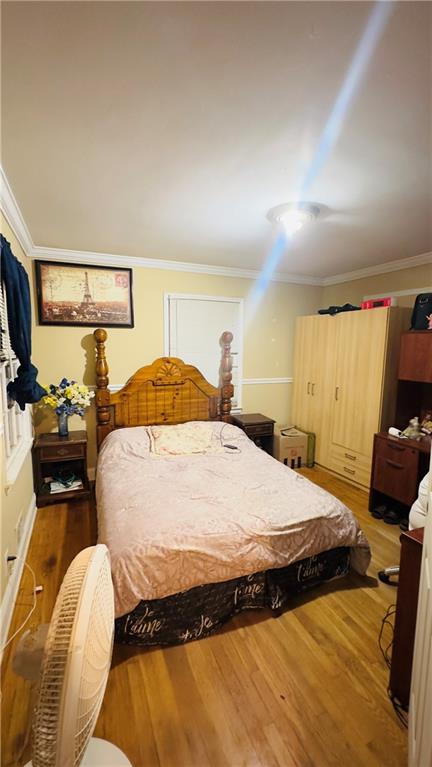 bedroom featuring hardwood / wood-style flooring and ornamental molding