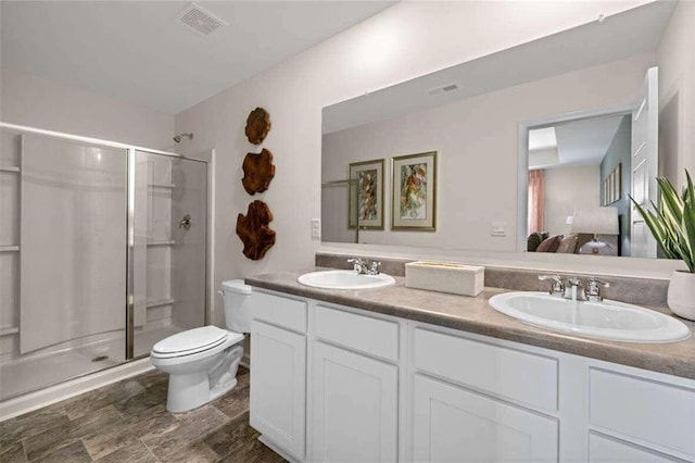 bathroom with vanity, a shower with shower door, and toilet